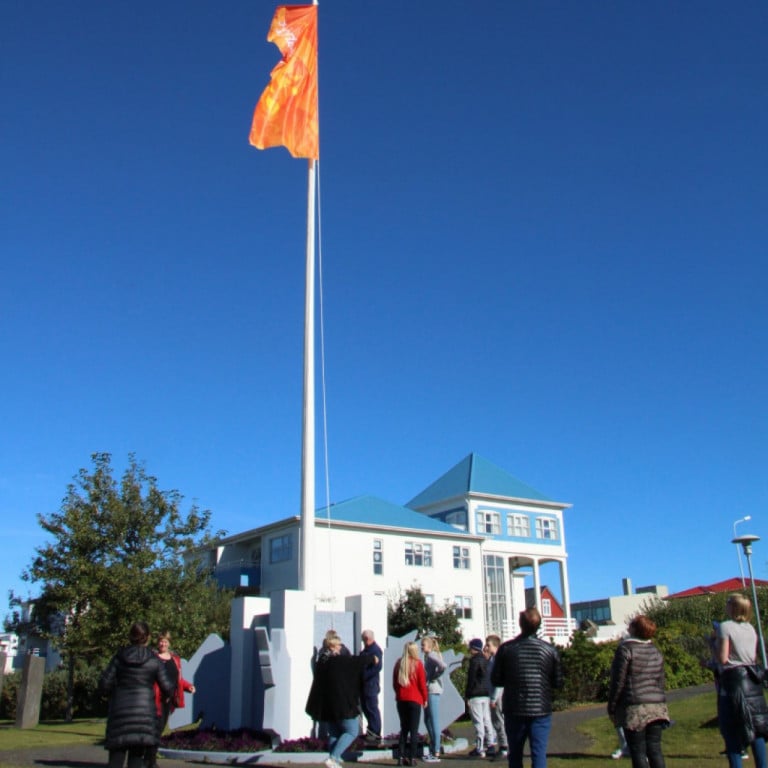 Ljósanæturfáninn blaktir við hún á hátíðarfánastöng í skrúðgarði