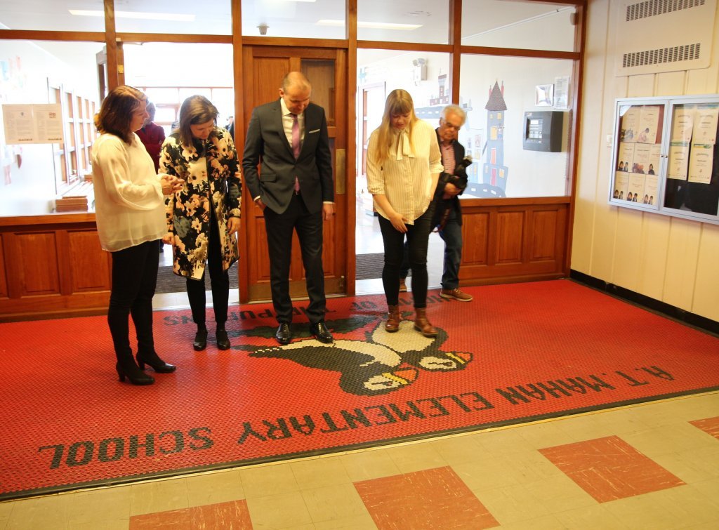 Gengið inn í húsakynni gamla barnaskólann á Keflavíkurflugvelli, sem nú er Háaleitisskóli. Söguleg motta er við innganginn