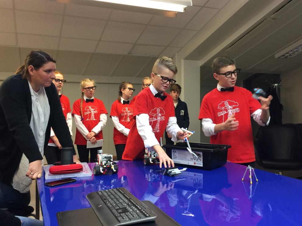 Sæþór Elí og Aron Gauti sýna virkni vélmennisins sem hópurinn smíðaði. Hjá stendur Íris Dröfn Halld…