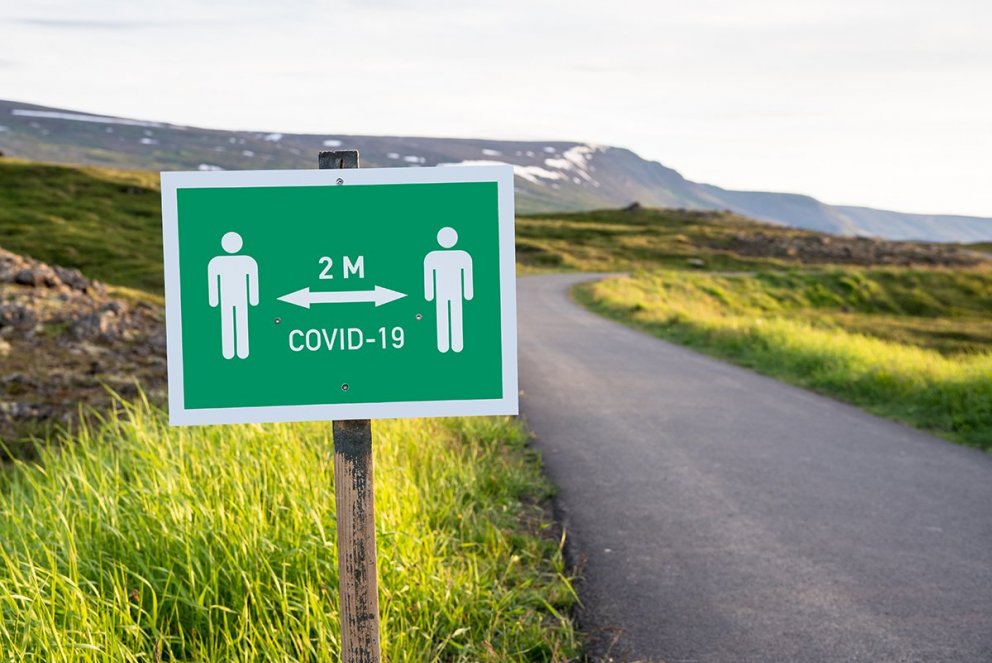 Skilti sem minnir fólk á að virða tveggja metra regluna