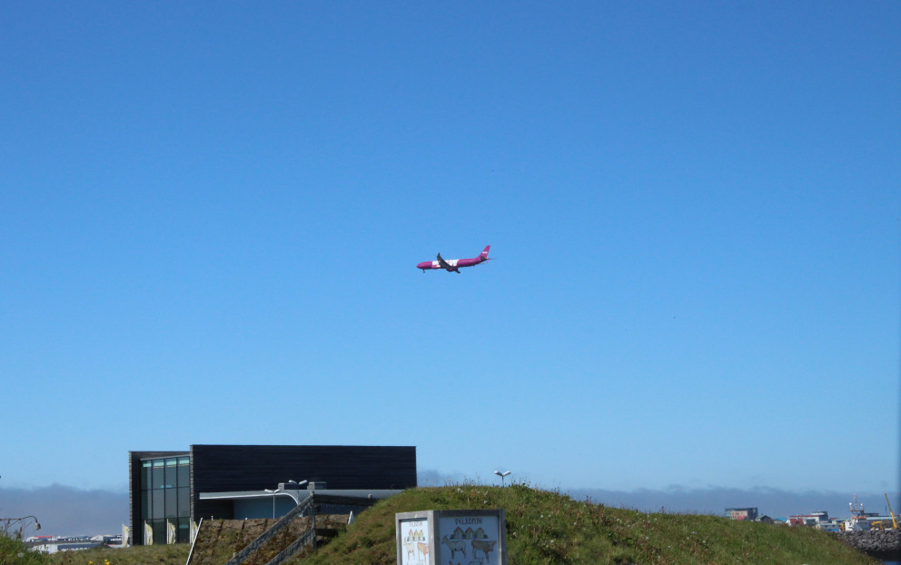 Flugvél frá Wow air yfir byggð í Reykjanesbæ.