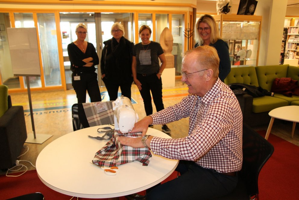 Kjartan Már Kjartansson bæjarstjóri kampakátur við saumaskapinn. Stefanía Gunnarsdóttir forstöðumað…