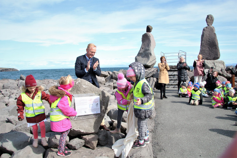 Kjartan Már Kjartansson afhjúpar skiltið með aðstoð nokkra af elstu leikskólabörnum Tjarnarsels. Þa…